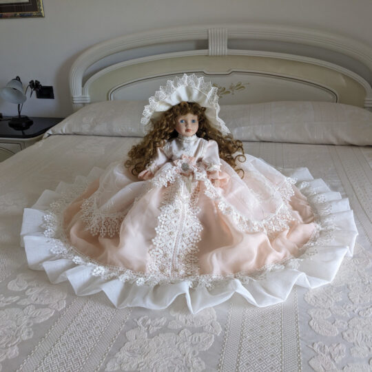 Bambola da letto modello "Beatrice" adagiata sul letto matrimoniale. Primo piano.