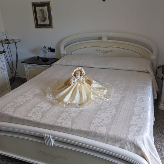 Bambola da letto modello "Camilla" adagiata sul letto matrimoniale. Vista obliqua.