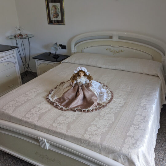 Bambola da letto modello "Diana" adagiata sul letto matrimoniale. Vista obliqua,